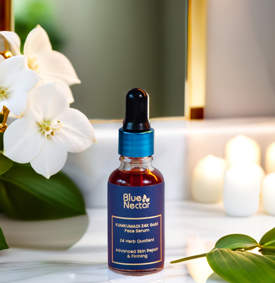 Blue Nectar Kumkumadi 24K Gold Serum with flowers and candles in the background.