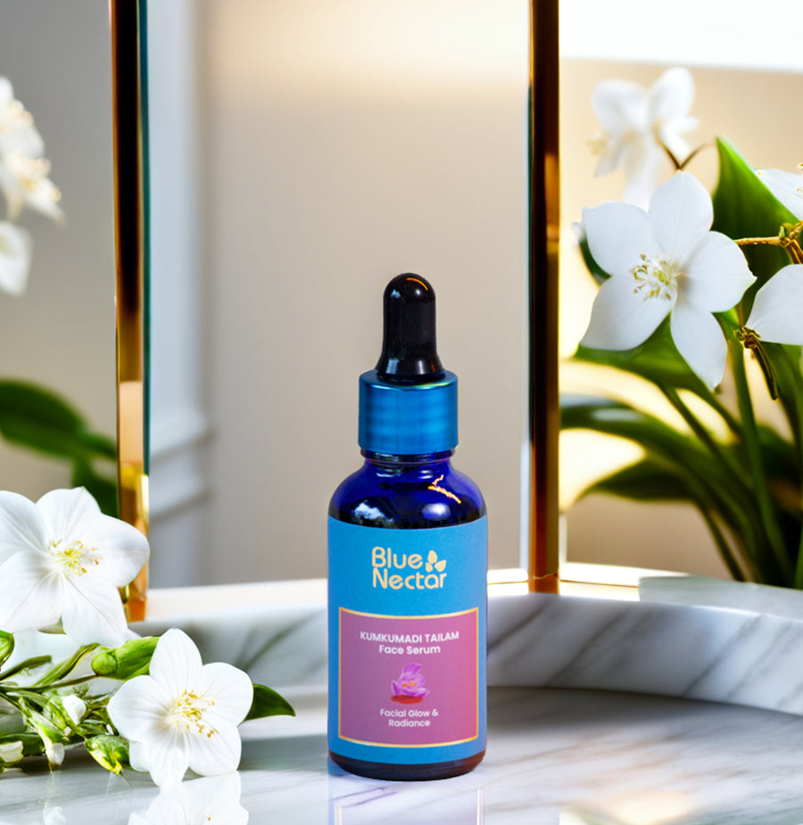 Blue Nectar Kumkumadi Face Serum with white flowers, reflecting glow and radiance.