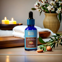 Niraa Nabhi Oil with Ghee & Almond Oil set in a spa-like ambiance with almonds, fresh towels, candles, and flowers.