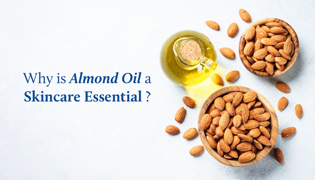 Two bowls filled with almonds and a bottle of almond oil is on a white table.