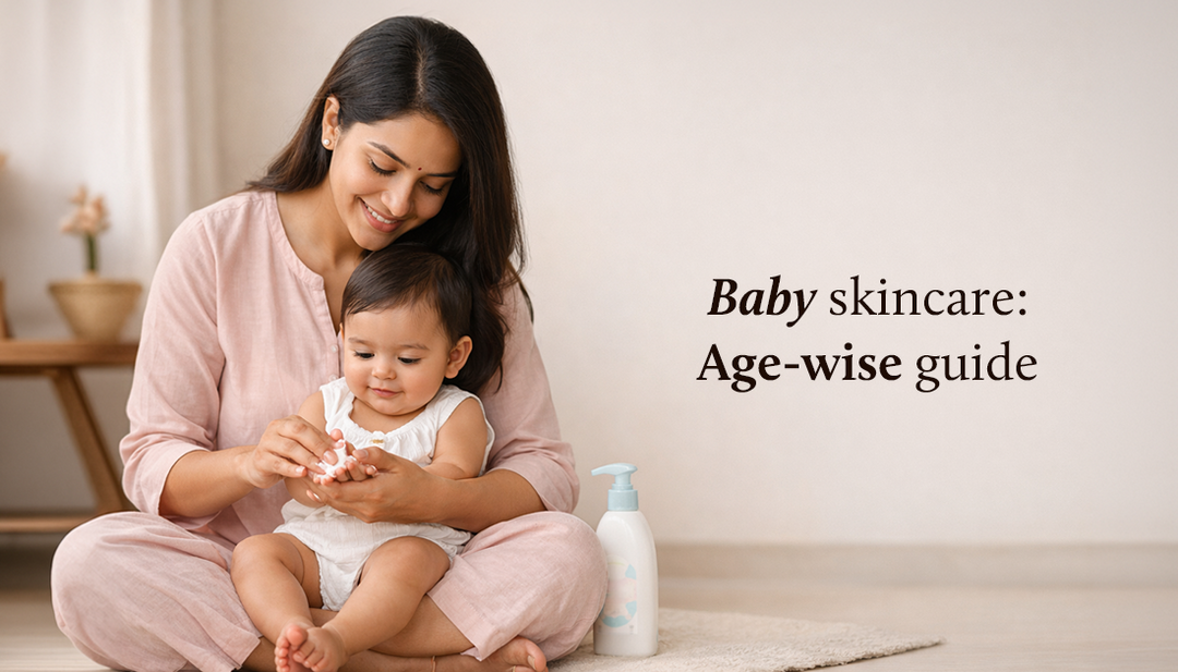 Mother sitting on the floor applying skincare cream to her baby’s hands, with a lotion bottle beside them and the text “Baby skincare: Age-wise guide” on the right.