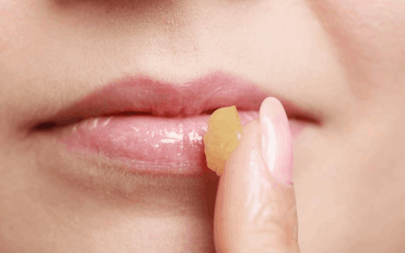 Girl is applying desi ghee on her lips with her finger