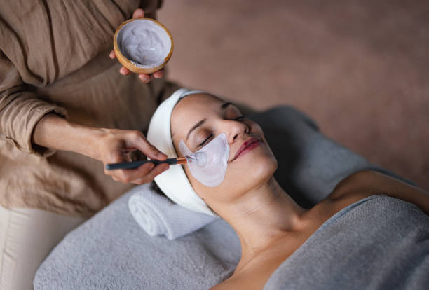 woman getting face mask applied by someone
