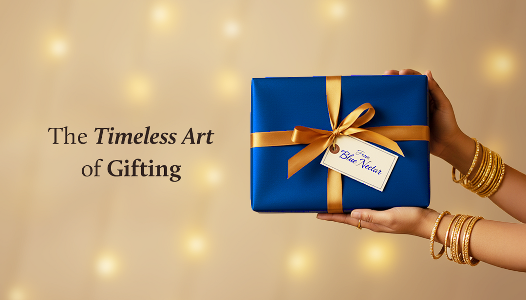 A lady is holding a blue gift box in her hand, with a tag on it that reads ‘From Blue Nectar.
