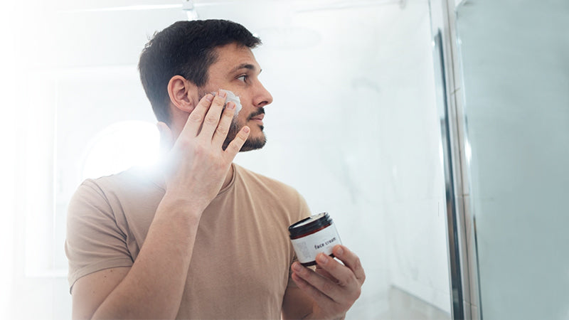 Men is applying best face cream for men on his face 