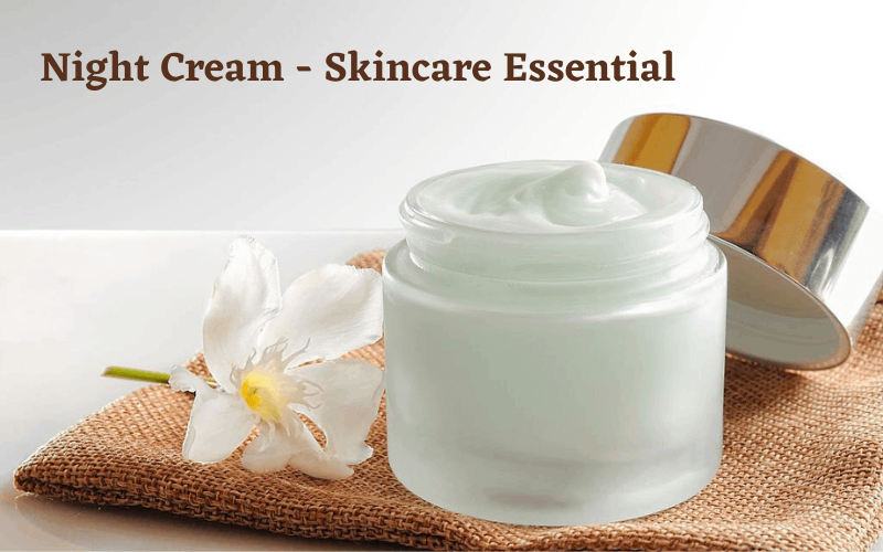 Night cream , white flower and lid of the cream is on brown cloth 