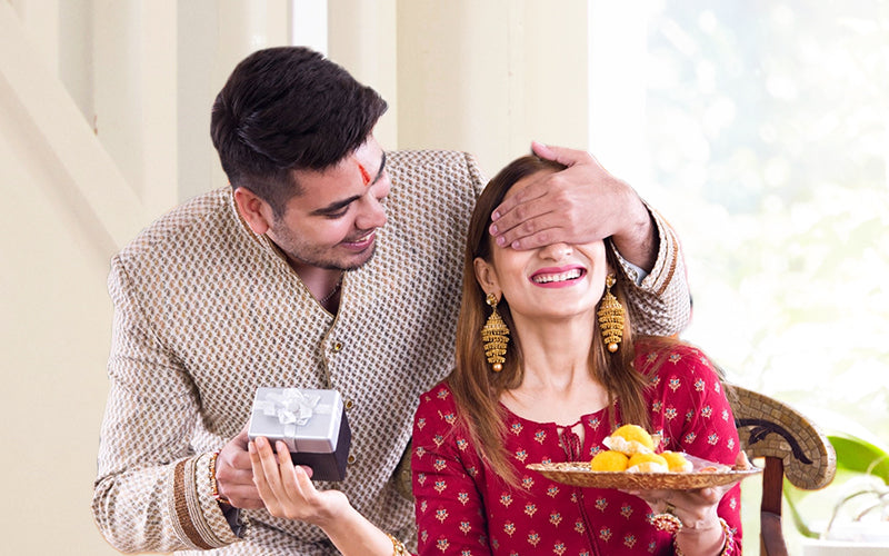 Brother is giving the gift box to her sister for rakshabandhan 