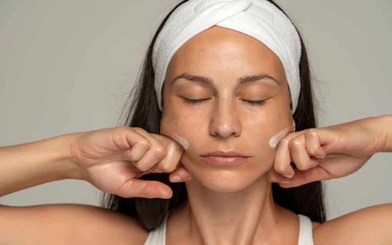 lady is doing facial massage with face cream for women