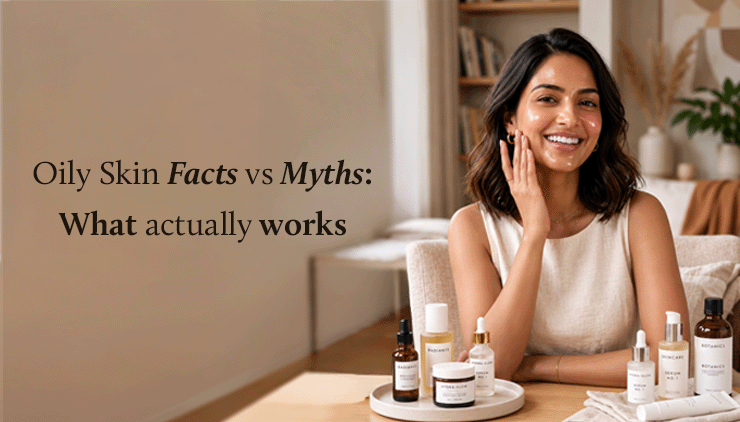 Smiling woman sits at a table with skincare products, touching her cheek. Text reads “Oily Skin Facts vs Myths: What actually works” in a cozy room.